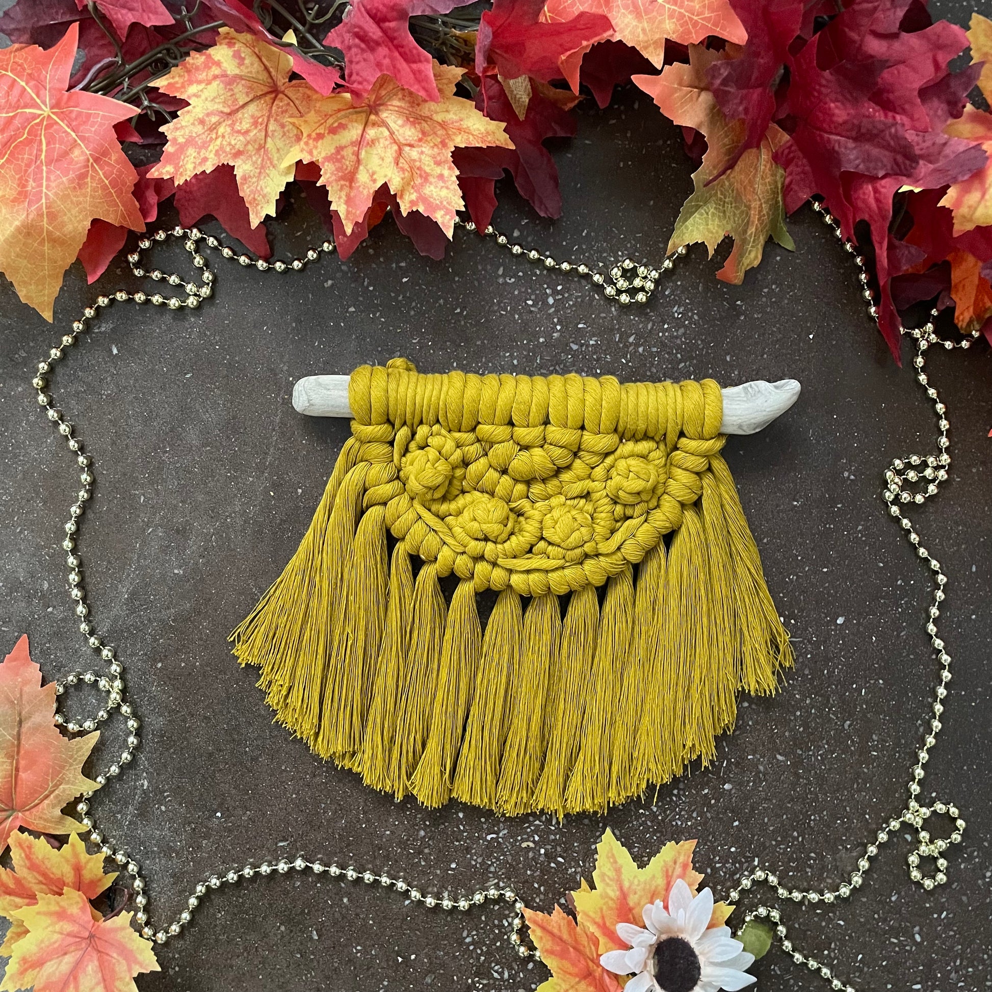 Sweater Weather Macramé Wall Hanging Spicy Yellow On Cement With Leaves