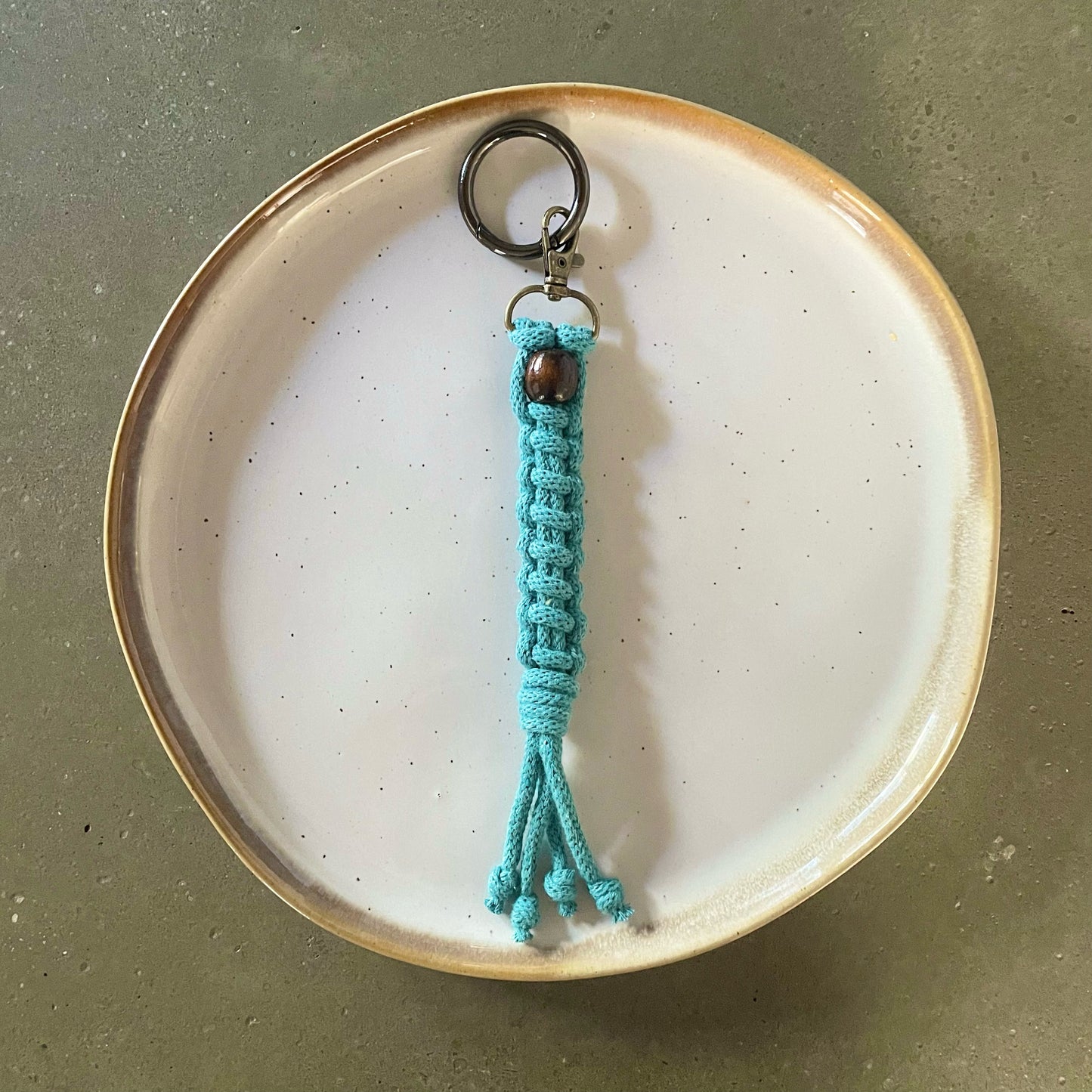 Key Chain centered on dinner plate. Straight ladder style in Teal