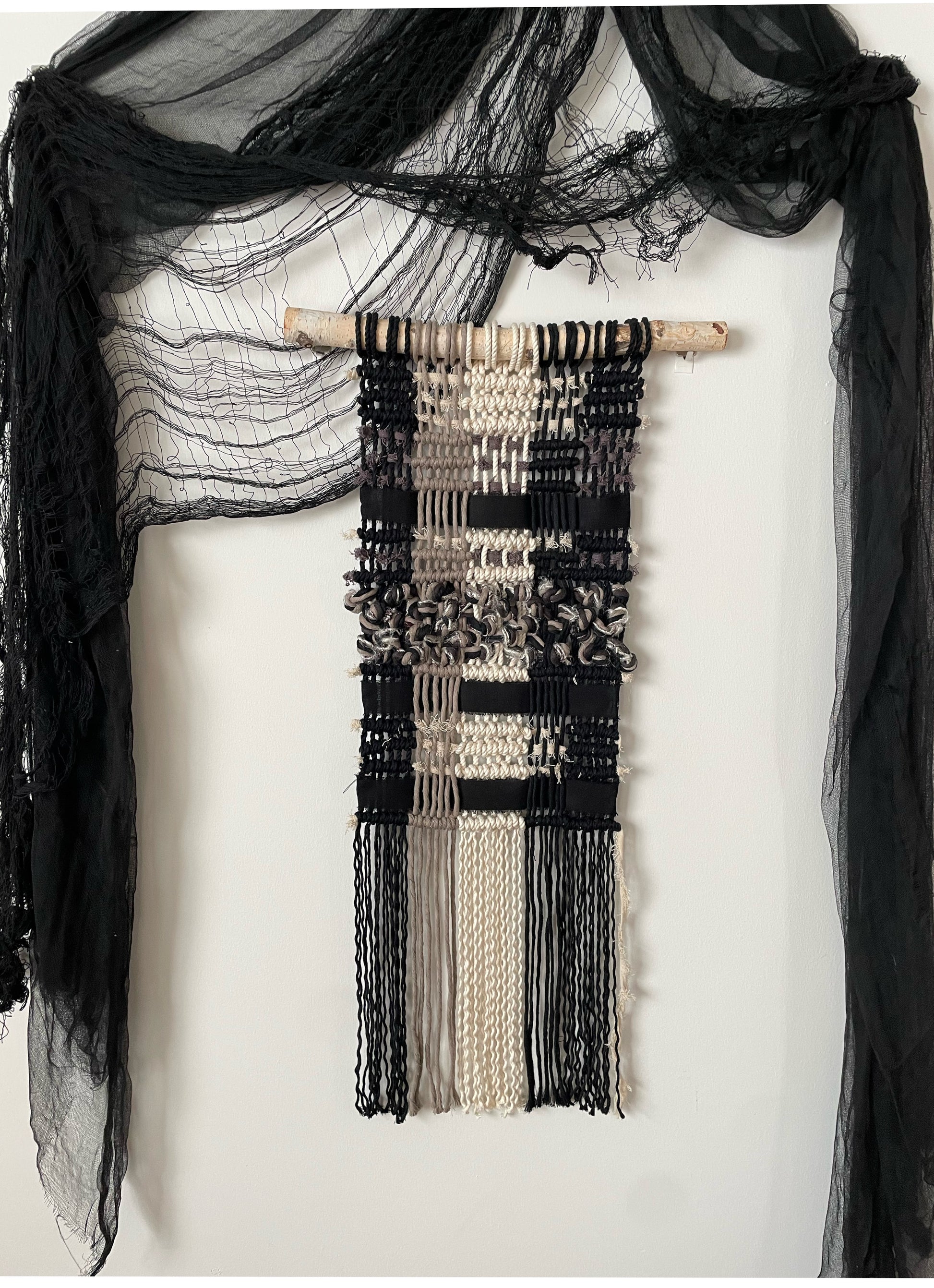 "Brambles" Macramé Wall Hanging on white wall with black halloween drapings