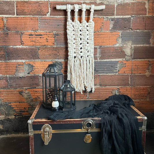 "Bones" Macramé Wall Hanging on brick wall with decor