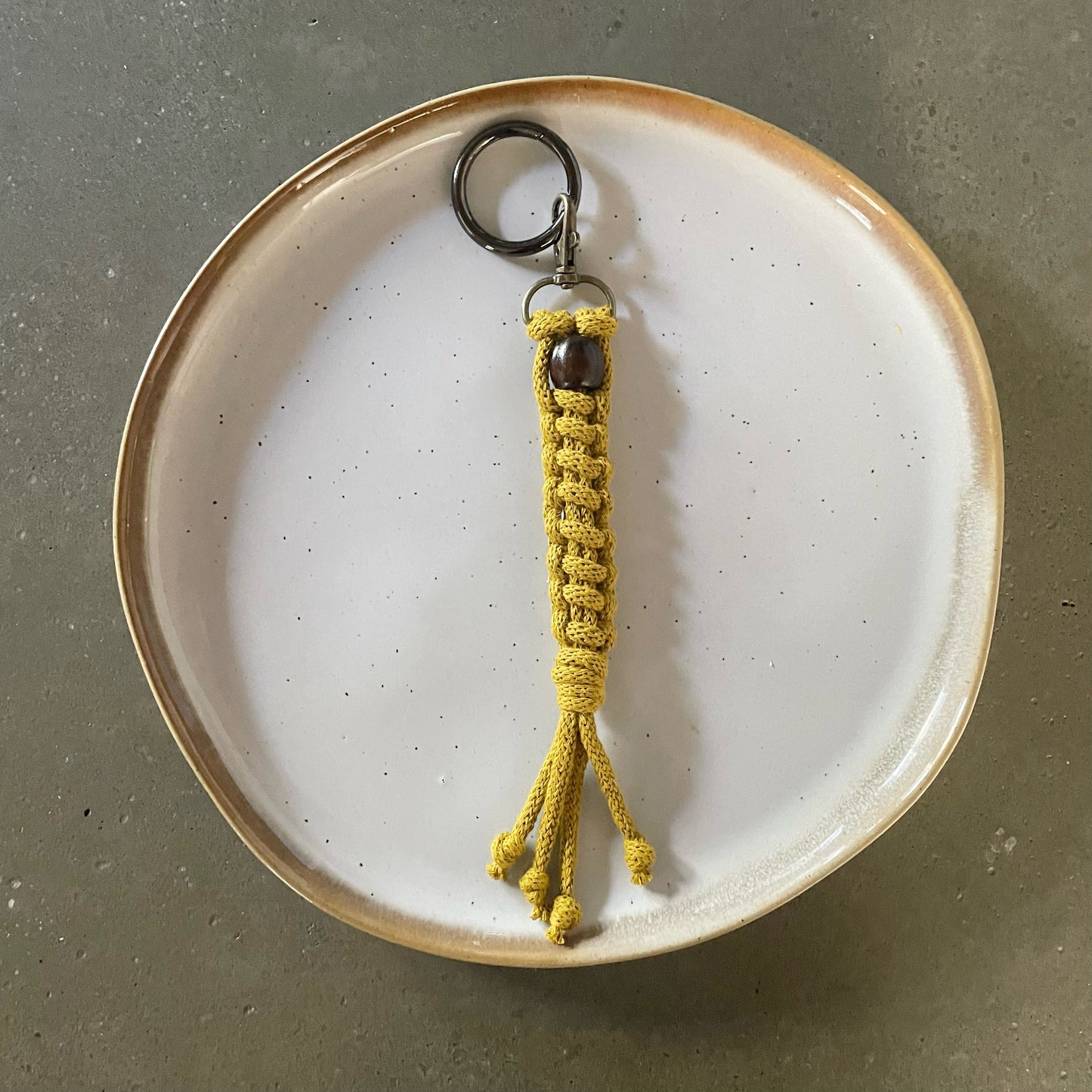 Key Chain centered on dinner plate. Straight ladder style in Spicy Mustard