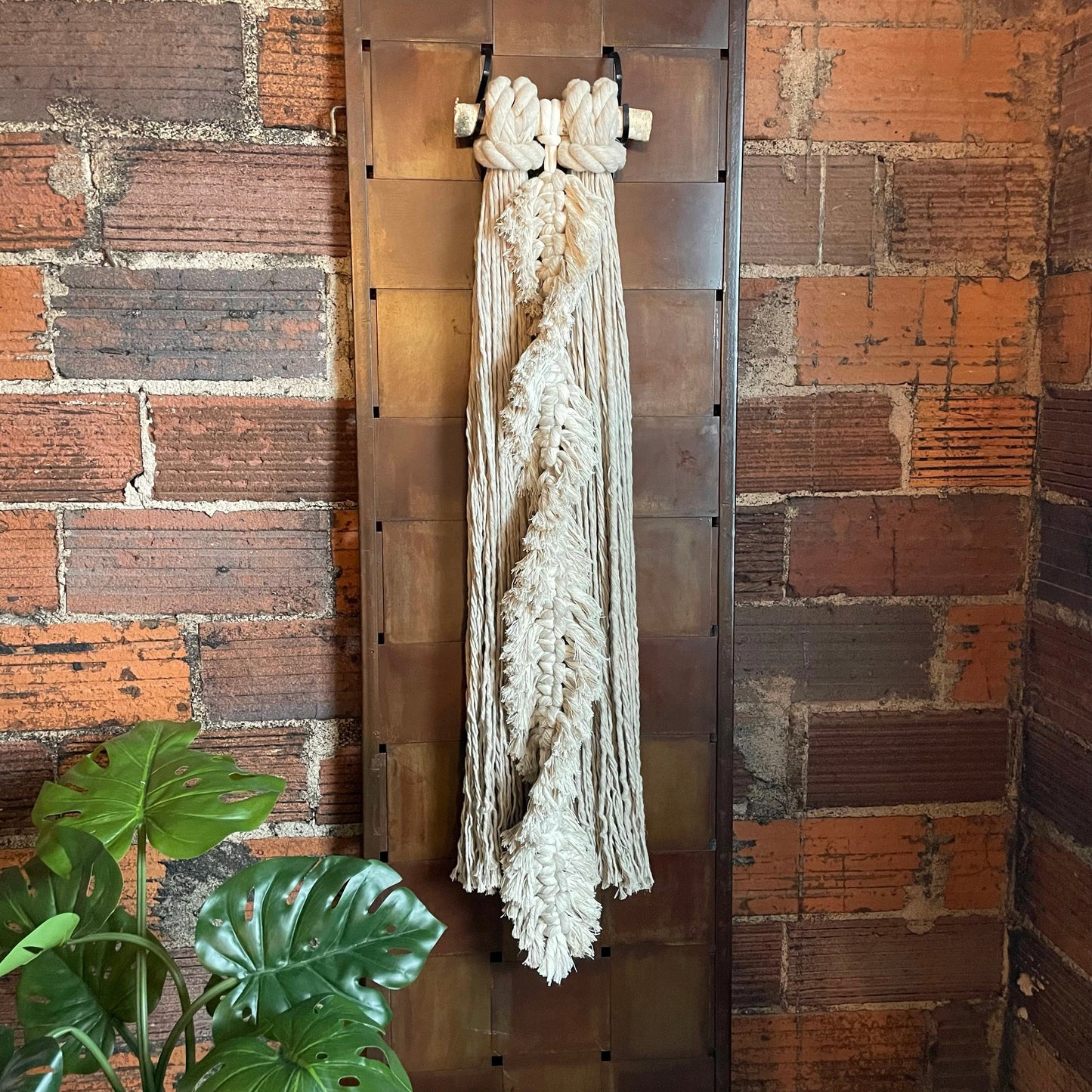 Feathery Fringe Solo Macrame Wall Hanging On Brick Wall