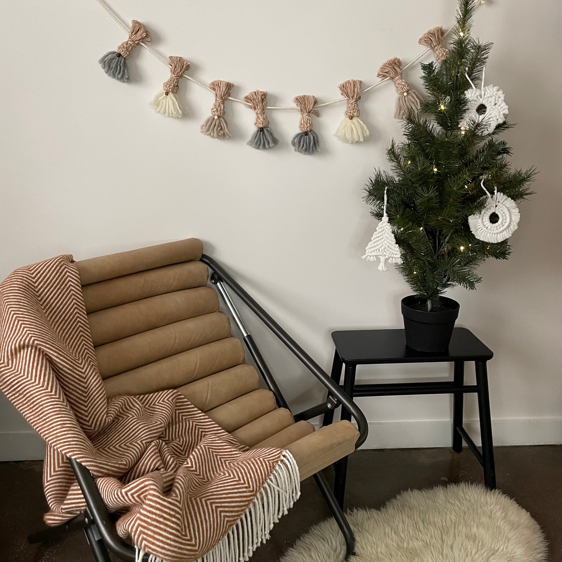 Cozy Gnome Garland hung on wall with cozy chair and holiday tree decor